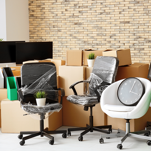 moving boxes and wrapped office furniture in an office building